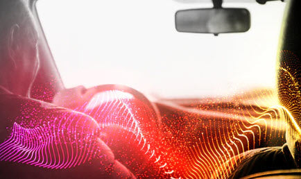 man driving car, white light in front, sound waves of color over image