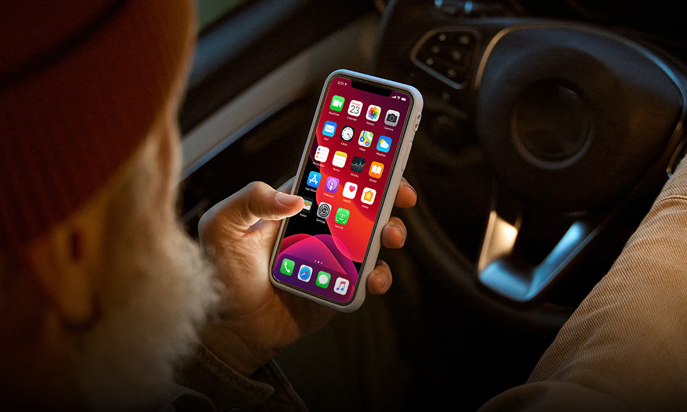 man holding phone checking apps in car