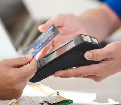 hands scanning credit card into payment device
